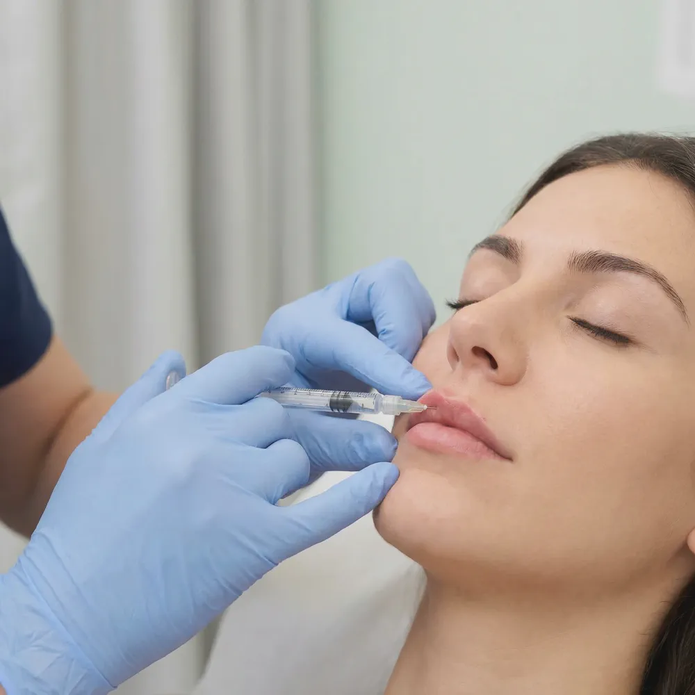 Close-up of a medical professional carefully injecting dermal filler near a patient's lips