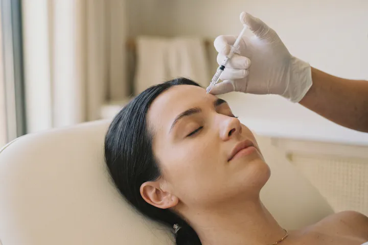 Provider holding a fine syringe above the relaxed forehead of a reclined client at Beautiful Body and Beyond in Corona, CA