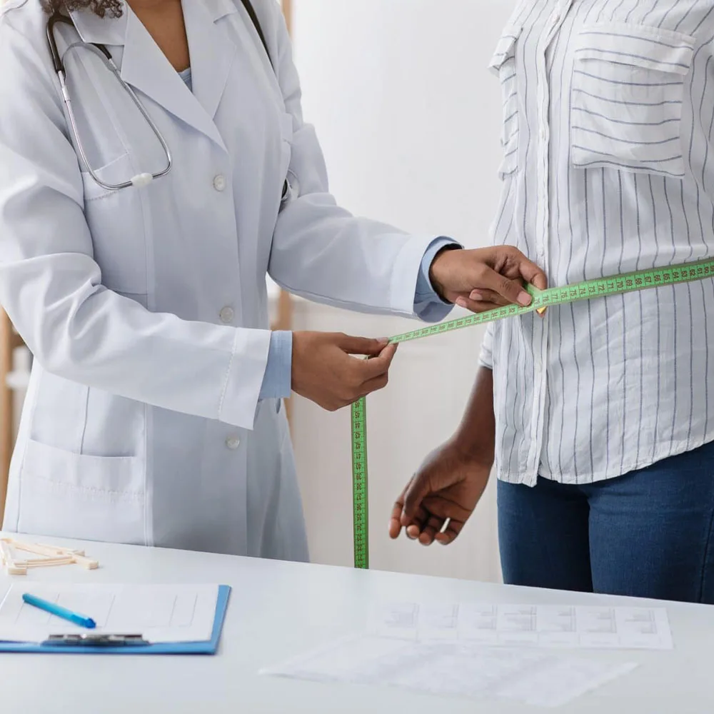 Medical provider measuring a patient's waist during a weight-loss consultation